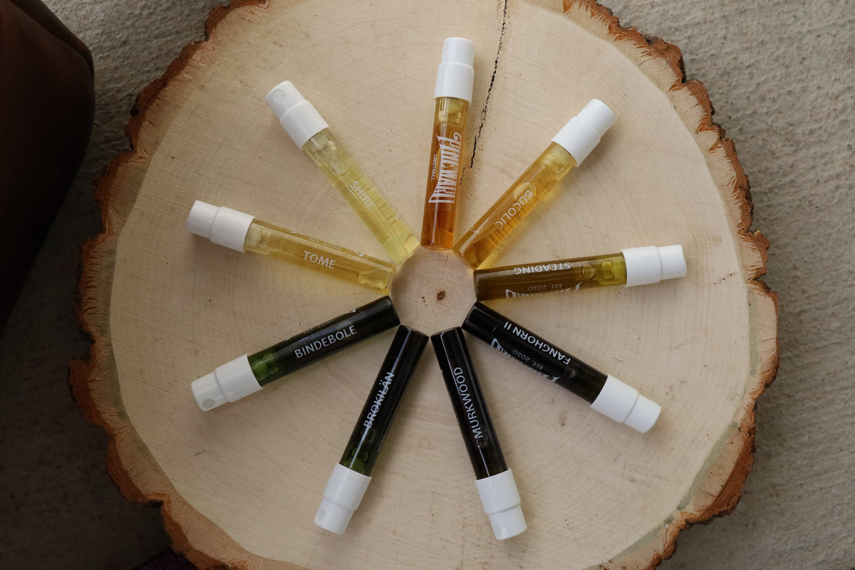 Assorted fragrance oil bottles on a round wood slice display
