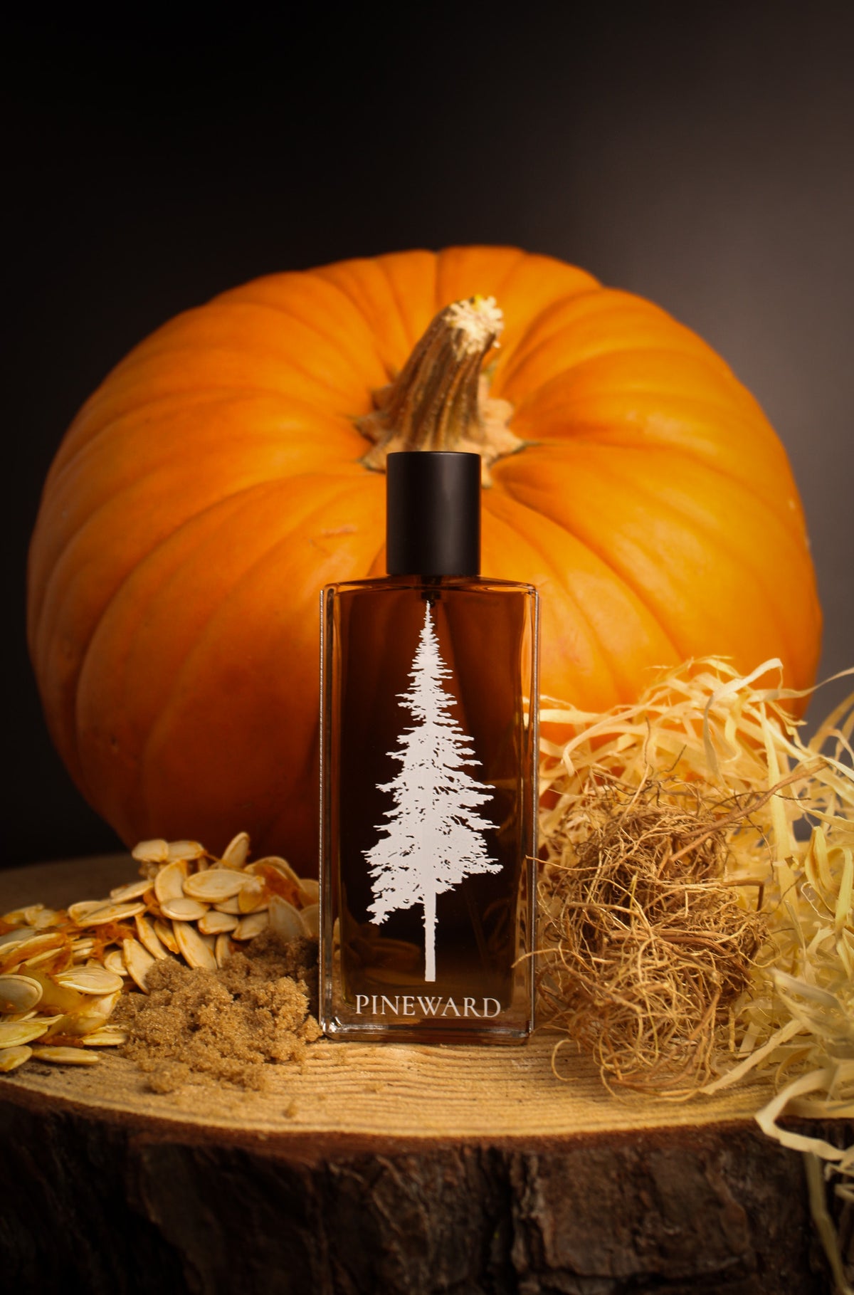 Amber glass perfume bottle with black cap and white pine tree label on front